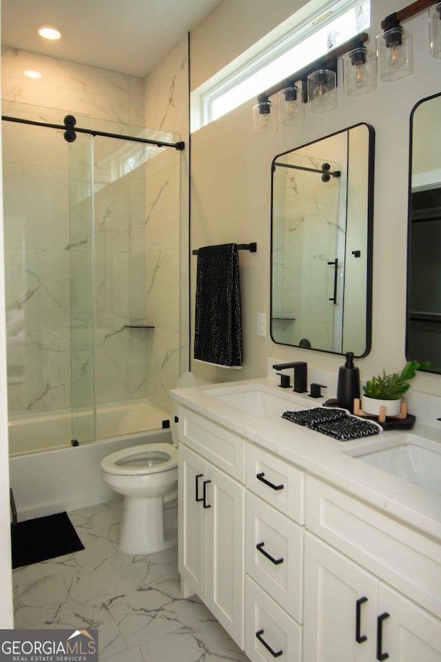 full bath with toilet, shower / bath combination with glass door, a sink, marble finish floor, and double vanity