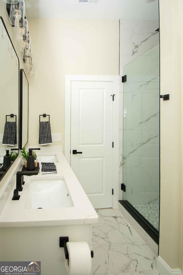 full bath with marble finish floor, a marble finish shower, visible vents, and a sink