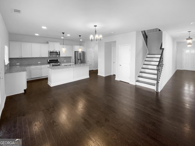 kitchen featuring stainless steel appliances, visible vents, white cabinetry, tasteful backsplash, and dark wood finished floors