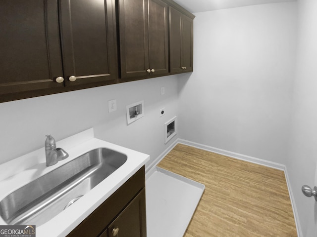 laundry room with washer hookup, cabinet space, a sink, electric dryer hookup, and wood finished floors