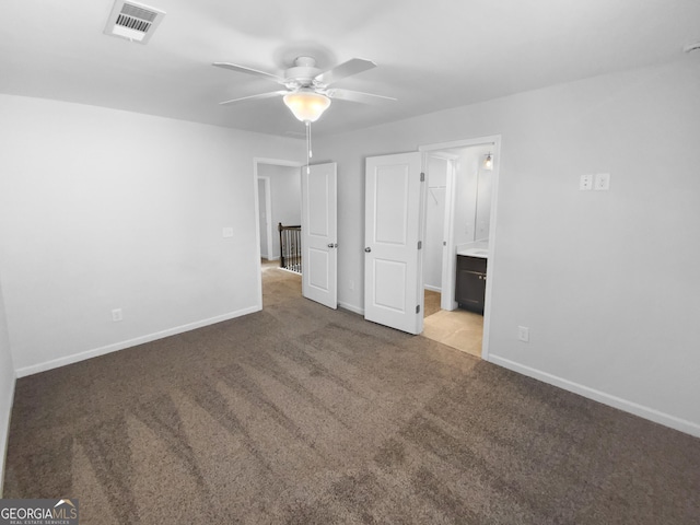 unfurnished bedroom with baseboards, visible vents, ensuite bath, ceiling fan, and carpet flooring