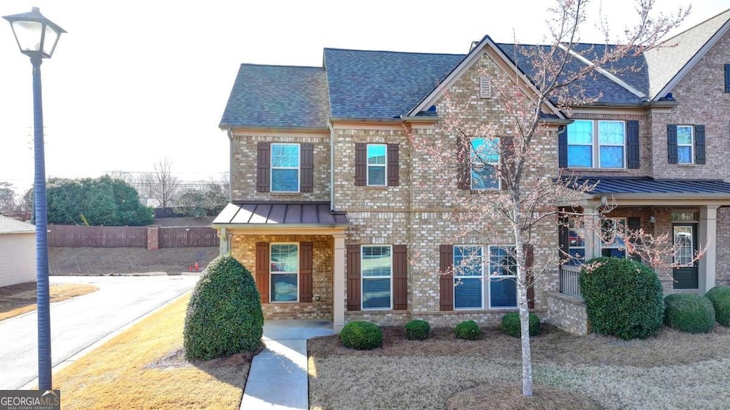 craftsman inspired home featuring a standing seam roof, metal roof, and brick siding