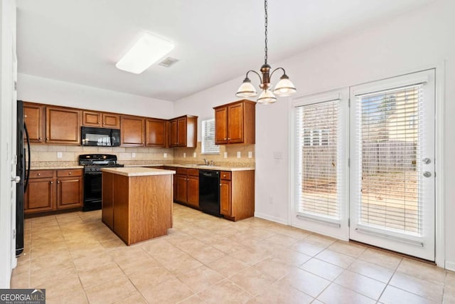 kitchen with tasteful backsplash, brown cabinetry, a kitchen island, light countertops, and black appliances