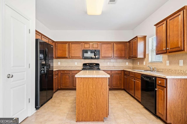 kitchen featuring tasteful backsplash, light countertops, a kitchen island, a sink, and black appliances