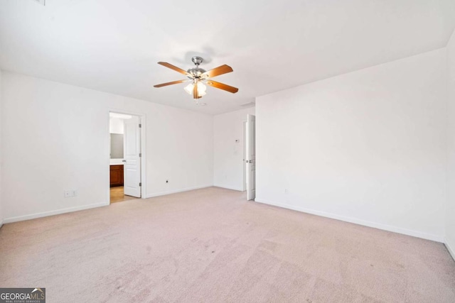 empty room featuring light carpet, baseboards, and a ceiling fan