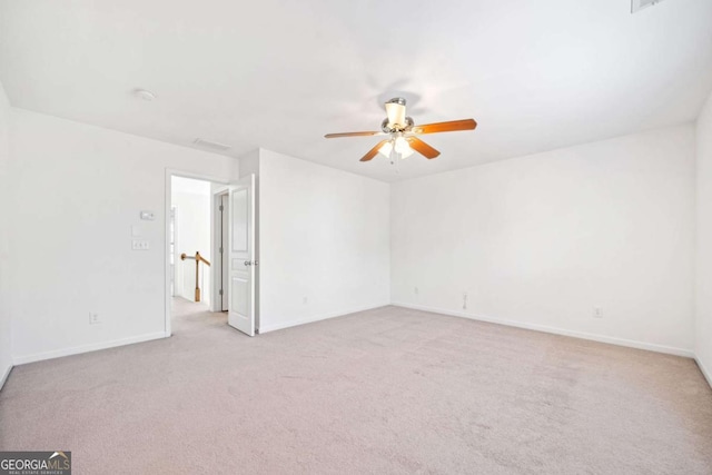 empty room featuring light carpet, ceiling fan, and baseboards