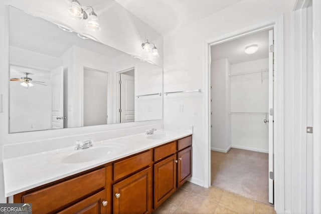 bathroom with tile patterned flooring, a sink, a spacious closet, and double vanity