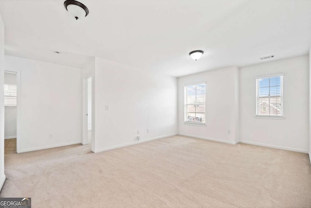 empty room with light carpet, baseboards, and visible vents