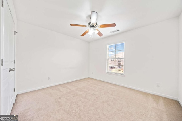 empty room featuring ceiling fan, carpet floors, visible vents, and baseboards