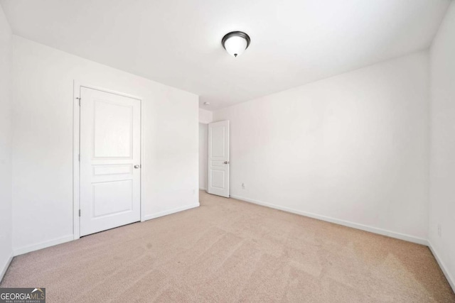 unfurnished bedroom with light carpet and baseboards