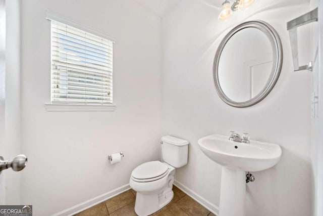 bathroom featuring toilet, baseboards, and tile patterned floors