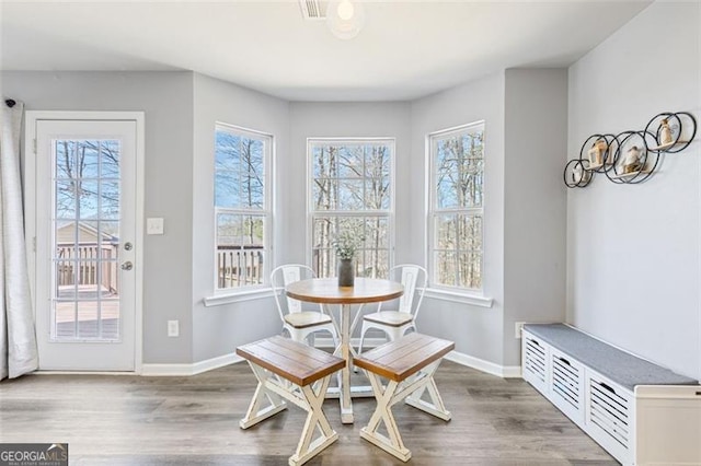 dining area with visible vents, wood finished floors, baseboards, and a wealth of natural light