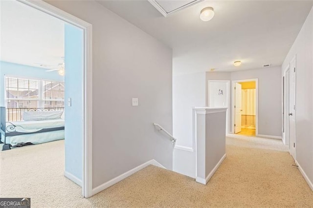 hall featuring baseboards, an upstairs landing, and carpet