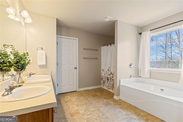 bathroom featuring a bath, visible vents, baseboards, and a sink