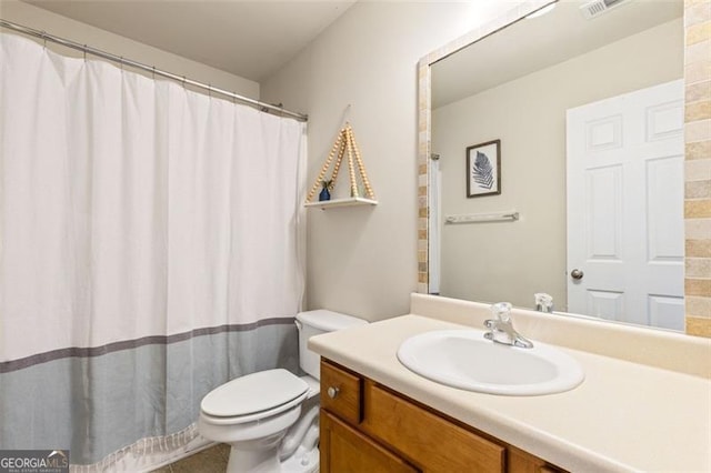 bathroom featuring visible vents, toilet, vanity, and a shower with curtain