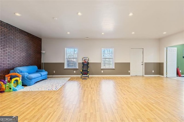 exercise area with recessed lighting, wood finished floors, and a wainscoted wall