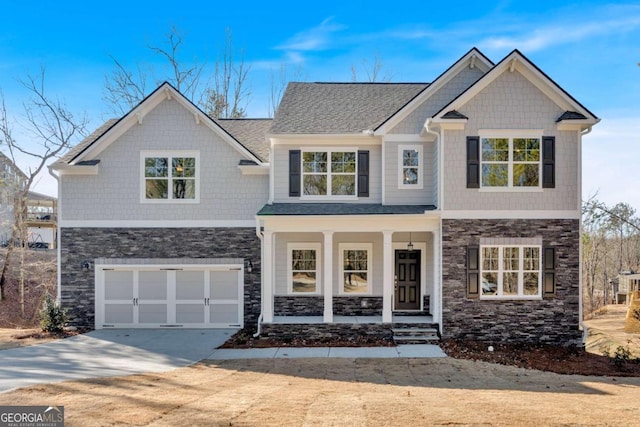 craftsman-style house featuring driveway, a garage, a shingled roof, stone siding, and a porch