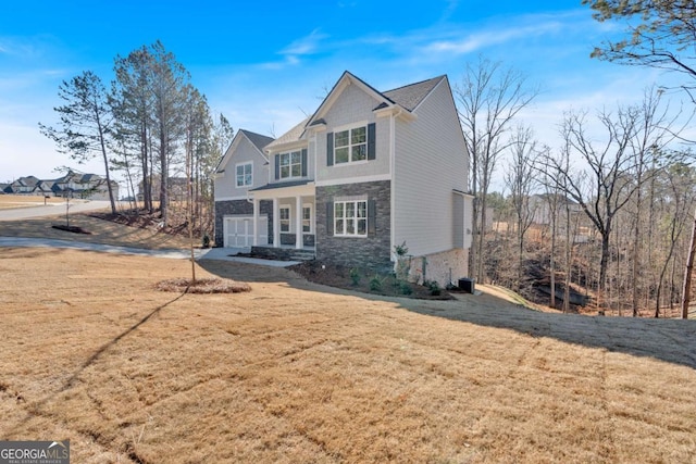 view of front facade featuring a garage, stone siding, and a front lawn