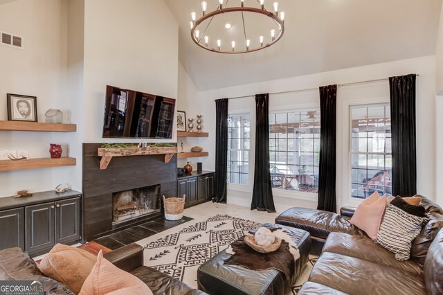 living room with a fireplace with flush hearth, plenty of natural light, visible vents, and a notable chandelier