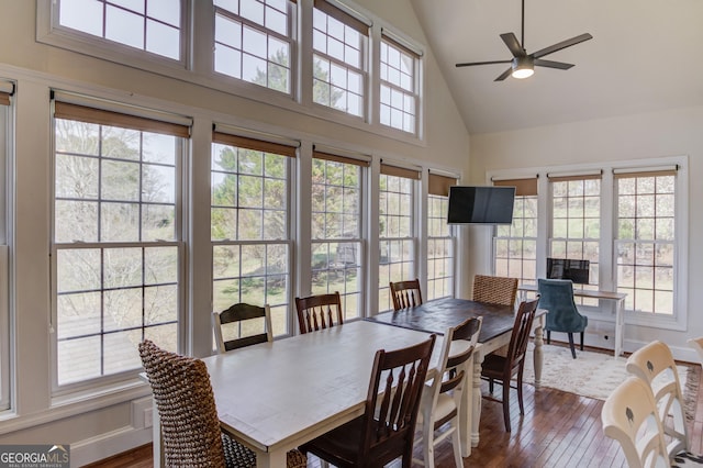 dining area with ceiling fan, high vaulted ceiling, dark wood-type flooring, and baseboards