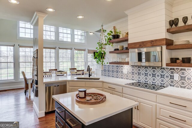 kitchen featuring a sink, black electric stovetop, open shelves, and dishwasher