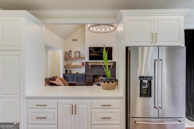 kitchen featuring visible vents, white cabinets, high end fridge, and light countertops