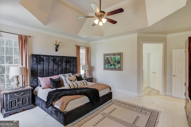 bedroom with a tray ceiling, crown molding, light wood-style floors, a ceiling fan, and baseboards