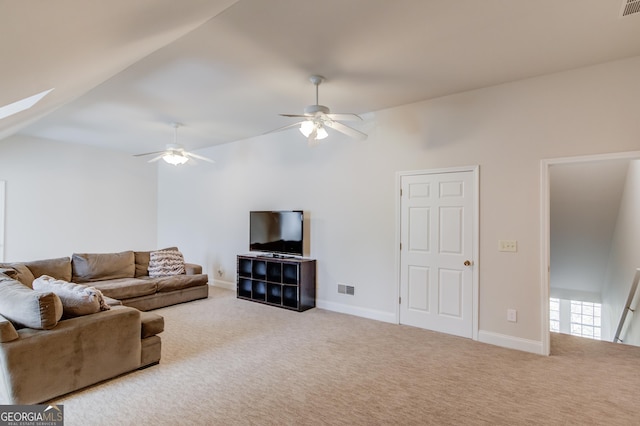 living room featuring carpet floors, a skylight, visible vents, and ceiling fan