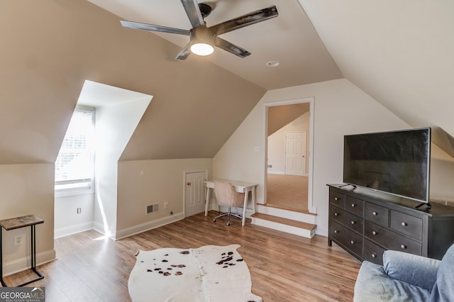 living area with a ceiling fan, lofted ceiling, visible vents, and wood finished floors