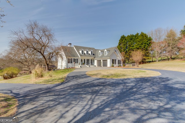 view of front of house featuring aphalt driveway, a front lawn, and an attached garage