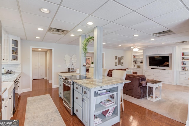 kitchen with visible vents, appliances with stainless steel finishes, light stone counters, white cabinetry, and open shelves