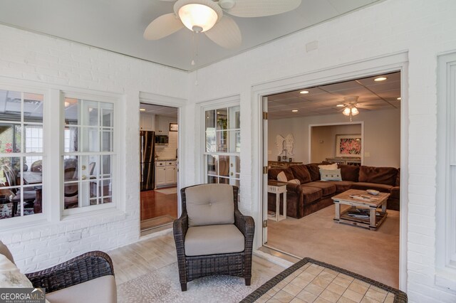 sunroom / solarium featuring a healthy amount of sunlight and ceiling fan