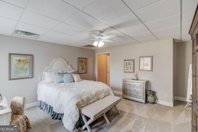 bedroom featuring visible vents, a drop ceiling, and light colored carpet