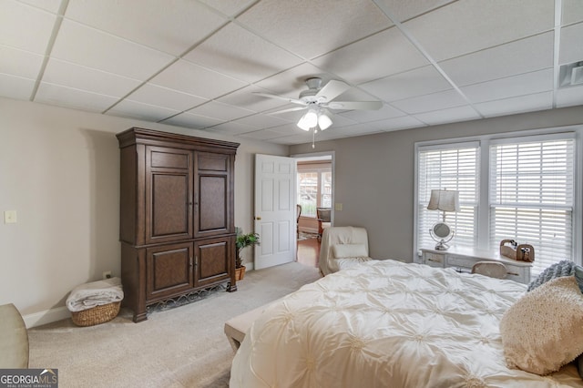 bedroom with light carpet, baseboards, a paneled ceiling, and a ceiling fan