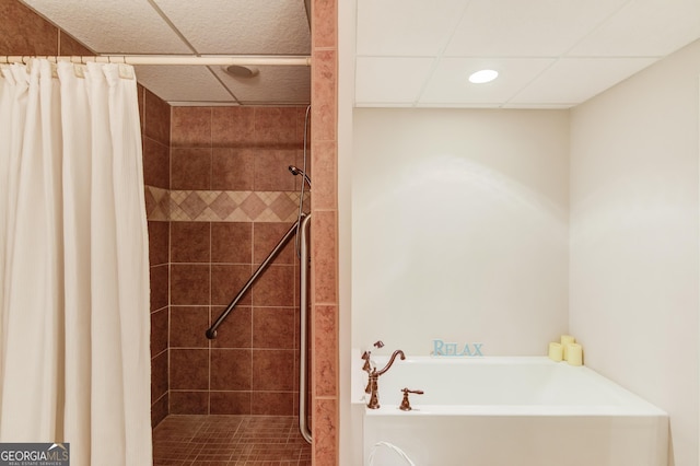 full bathroom featuring a garden tub, a tile shower, and a drop ceiling