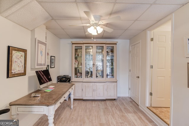 home office with a paneled ceiling, light wood-style flooring, and ceiling fan