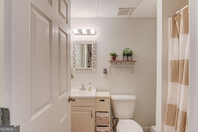 bathroom featuring visible vents, a shower with shower curtain, toilet, vanity, and a paneled ceiling