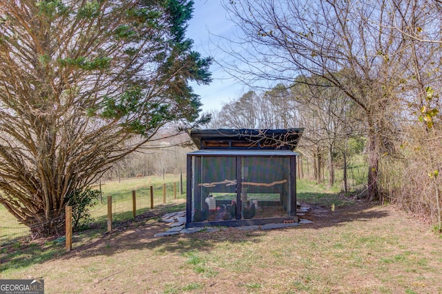 view of poultry coop featuring fence and a lawn