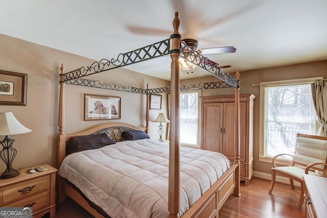 bedroom with light wood-type flooring, ceiling fan, and baseboards