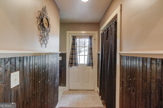 doorway to outside with light tile patterned flooring