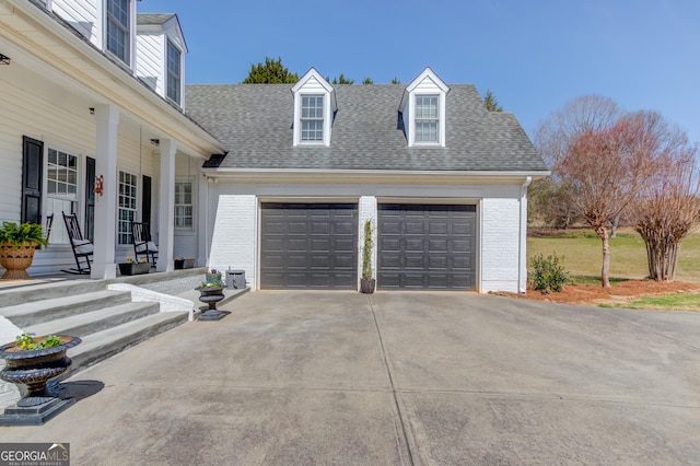 garage featuring concrete driveway and a porch