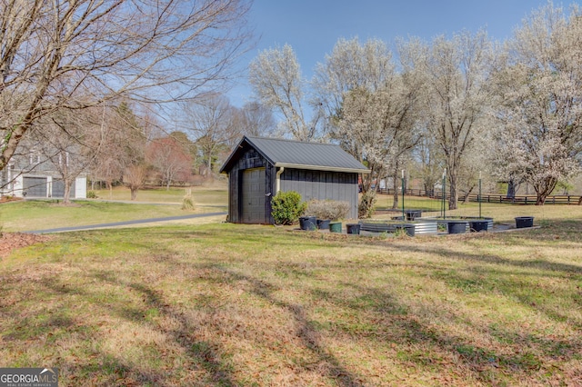 view of yard with a garage, an outdoor structure, and fence