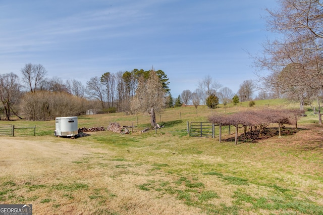 view of yard with fence and a rural view