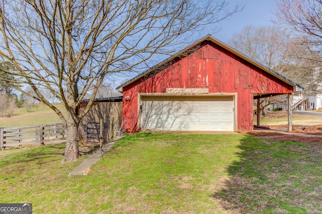 view of outdoor structure with an outbuilding, fence, and driveway