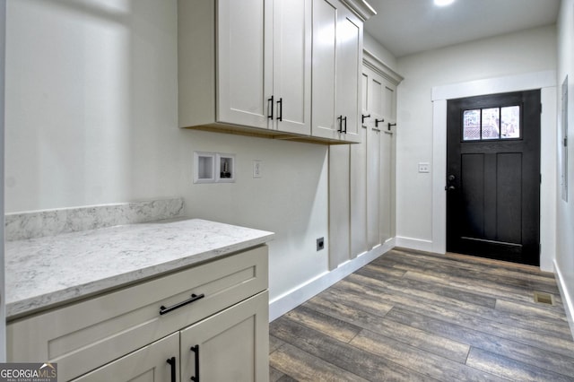 laundry area featuring dark wood-type flooring, washer hookup, cabinet space, and baseboards