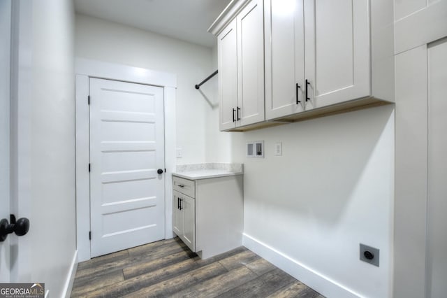 laundry room featuring cabinet space, baseboards, dark wood-style flooring, hookup for a washing machine, and hookup for an electric dryer