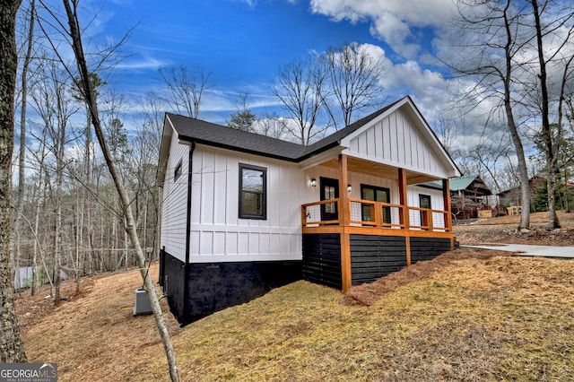 view of front of home featuring roof with shingles, board and batten siding, and central air condition unit