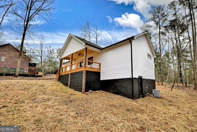 view of property exterior with a ceiling fan, central AC, and a deck