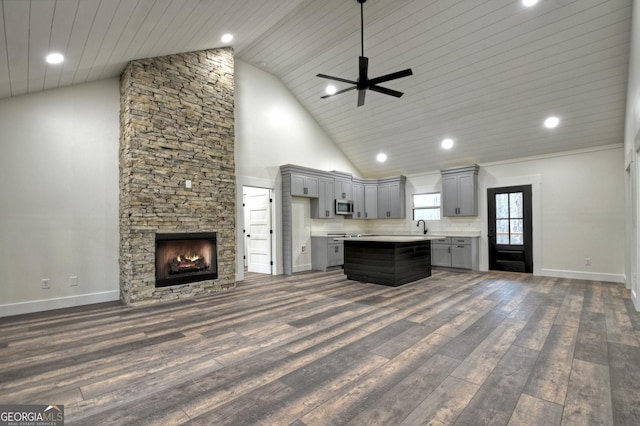 kitchen with gray cabinetry, open floor plan, light countertops, a center island, and stainless steel microwave