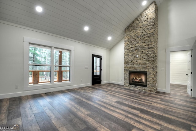 unfurnished living room featuring dark wood-type flooring, high vaulted ceiling, a stone fireplace, and baseboards